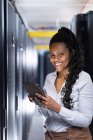 Tecnico informatico afroamericano femminile che utilizza tablet che lavora nella sala server. tecnologia digitale di memorizzazione delle informazioni e rete di comunicazione. — Foto stock