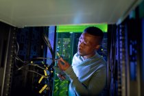 African american male computer technician working in server room. digital information storage and communication network technology. — Stock Photo