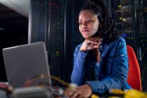 Tecnico informatico afroamericano femminile che utilizza laptop che lavorano nella sala server. tecnologia digitale di memorizzazione delle informazioni e rete di comunicazione. — Foto stock