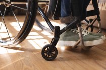 Низкая часть инвалида сидит дома на инвалидной коляске. Концепция инвалидности и инвалидности — стоковое фото