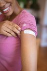 Mulher afro-americana sorridente mostrando bandagem no braço após vacinação vívida. cuidados de saúde e estilo de vida durante a pandemia de 19 pessoas. — Fotografia de Stock