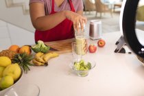 Midsection de mulher plus size preparando smoothie na cozinha. estilo de vida saudável, cozinhar e passar o tempo em casa. — Fotografia de Stock