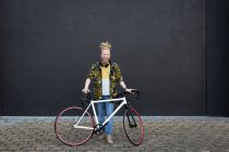 Retrato del sonriente hombre afroamericano albino con rastas en la calle con bicicleta. sobre la marcha, fuera y alrededor de la ciudad. - foto de stock