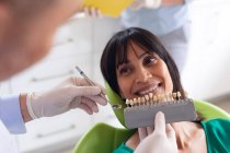 Dentista masculino caucasiano examinando dentes de paciente do sexo feminino na clínica odontológica moderna. serviços de saúde e odontologia. — Fotografia de Stock
