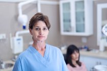 Portrait of smiling caucasian female dental nurse looking at camera at modern dental clinic. healthcare and dentistry business. — Stock Photo