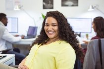 Retrato de mulher de negócios birracial sorridente olhando para a câmera no escritório moderno. empresa e escritório local de trabalho. — Fotografia de Stock
