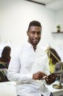 Портрет усміхненого афроамериканського бізнесмена, який користується планшетом і дивиться на камеру в сучасному офісі.. — стокове фото