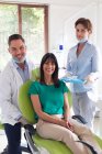 Ritratto di dentista sorridente, infermiera dentale e paziente presso la moderna clinica dentale. attività sanitaria e odontoiatrica. — Foto stock