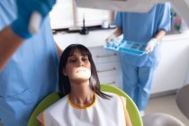 Il dentista maschio caucasico e l'infermiera dentale femminile esaminano i denti del paziente presso la moderna clinica dentale. attività sanitaria e odontoiatrica. — Foto stock