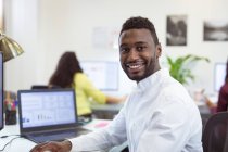 Портрет усміхненого афроамериканського бізнесмена, який дивиться на камеру в сучасному офісі. на роботі та в офісі. — стокове фото