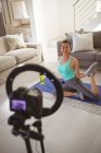 Heureuse femme asiatique exerçant sur le tapis, faire fittnes vlog de la maison. mode de vie actif sain et forme physique à la maison grâce à la technologie. — Photo de stock