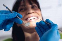 Kaukasischer Zahnarzt untersucht die Zähne einer Patientin in einer modernen Zahnklinik. Gesundheits- und Zahnarztgeschäft. — Stockfoto