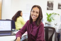 Retrato de mulher de negócios birracial sorridente olhando para a câmera no escritório moderno. empresa e escritório local de trabalho. — Fotografia de Stock