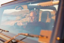 Homem caucasiano pensativo sentado no carro à beira-mar admirando a vista. viagem de verão e férias na natureza. — Fotografia de Stock