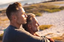 Feliz caucasiano gay masculino casal abraçando no sol à beira-mar. viagem de verão e férias na natureza. — Fotografia de Stock