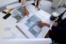 High angle view of female architects discussing over blueprint at desk in creative office. business, architect and creative office. — Stock Photo