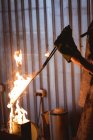 Gehackte Hände eines Schmieds, der Metall in Brand setzt, während er in der verarbeitenden Industrie schmiedet. Schmiede-, Metall- und Fertigungsindustrie. — Stockfoto