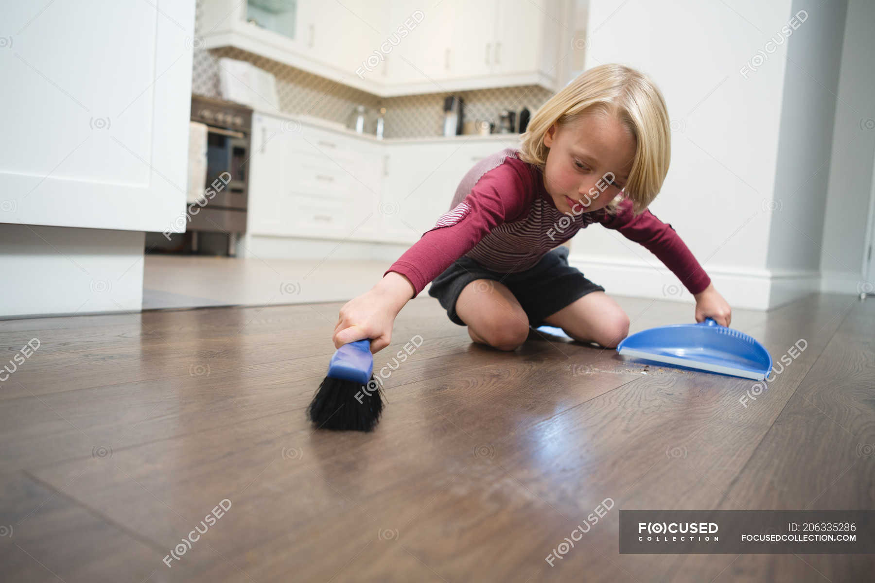 Boy sweeping dust with brush and dust pan at home — neat, hygiene