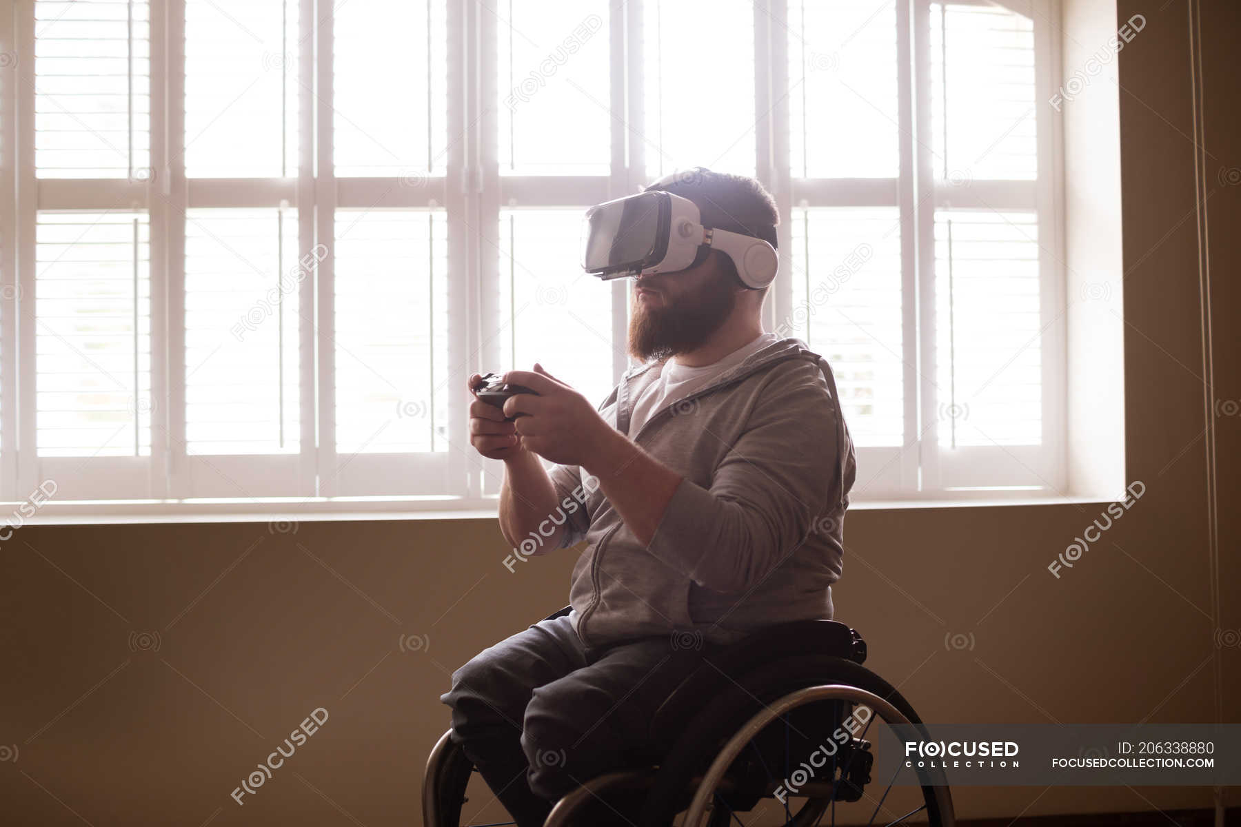 Disabled man using virtual reality headset at home — authentic, Physical Impairment Stock