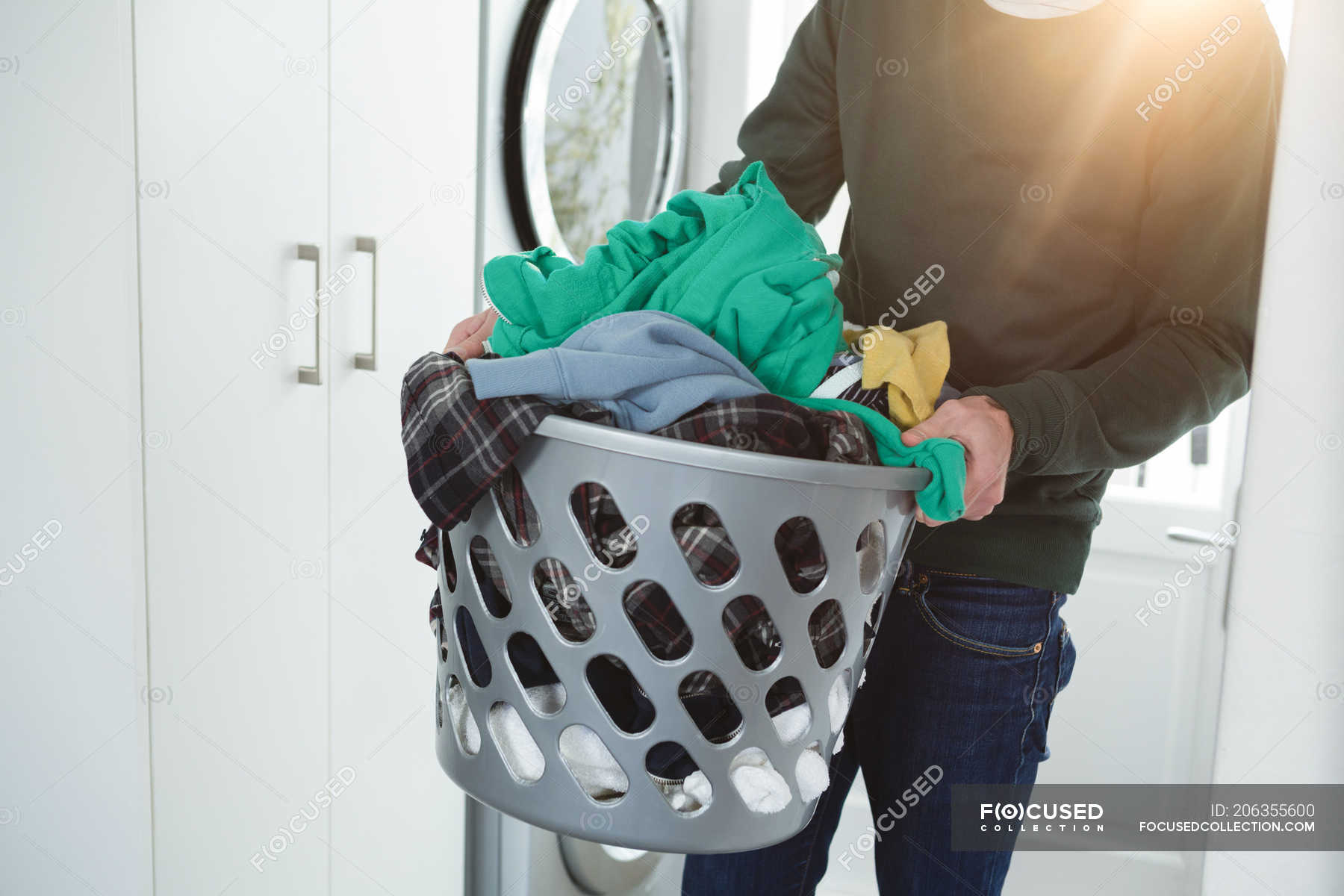 elleboog pomp Claire Man holding basket of laundry clothes at home — self isolation, indoors -  Stock Photo | #206355600