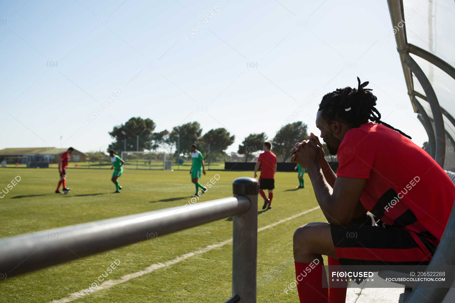 Side view of player watching the football match from dugout — sitting ...