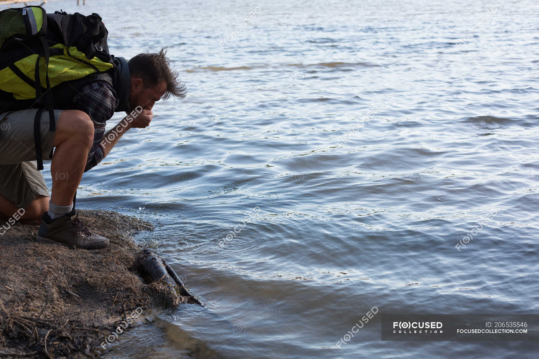 side-view-of-male-hiker-drinking-water-from-river-summer-solitary