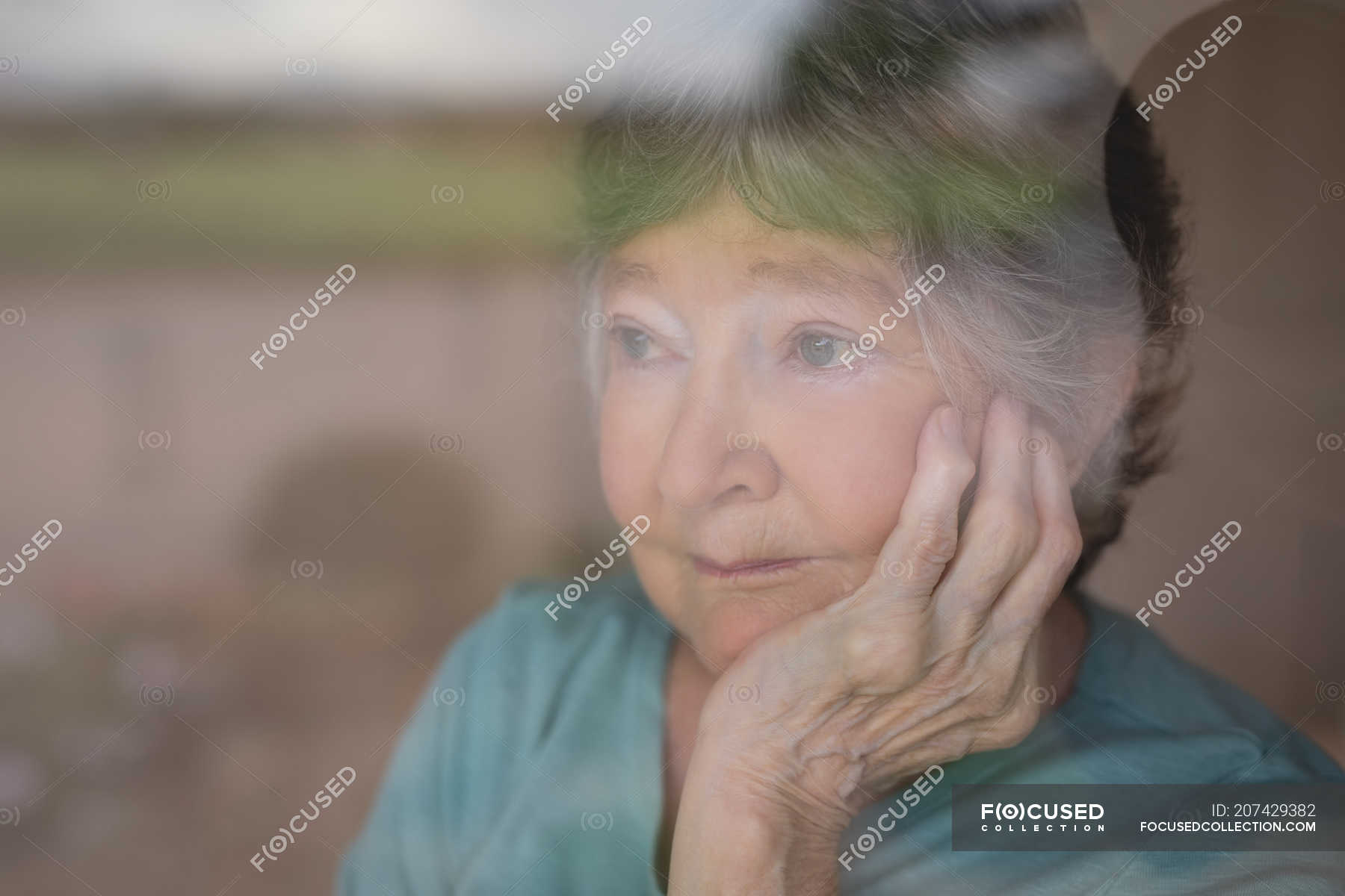 Thoughtful senior woman looking outside window — people, Hand On Chin ...