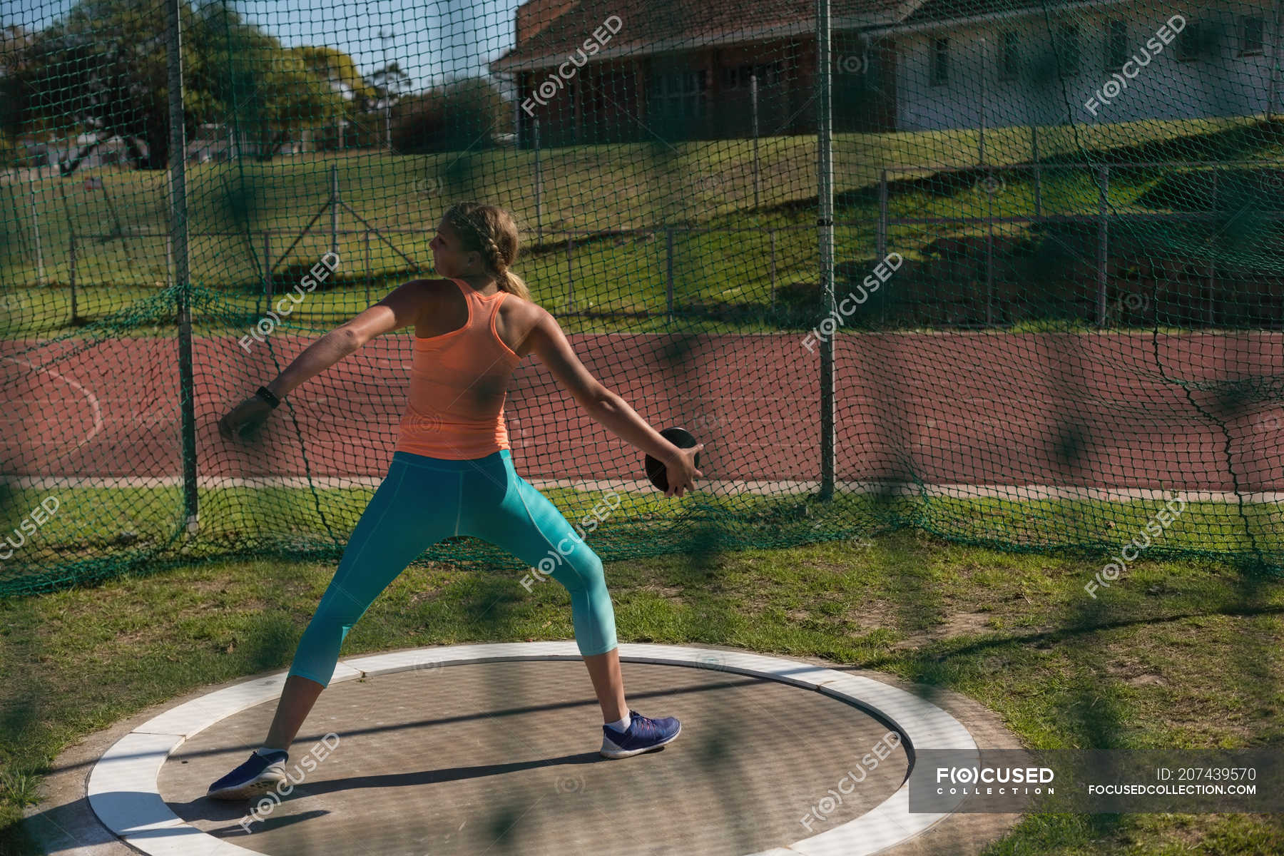 Female athlete practicing discus throw at sports venue — skill