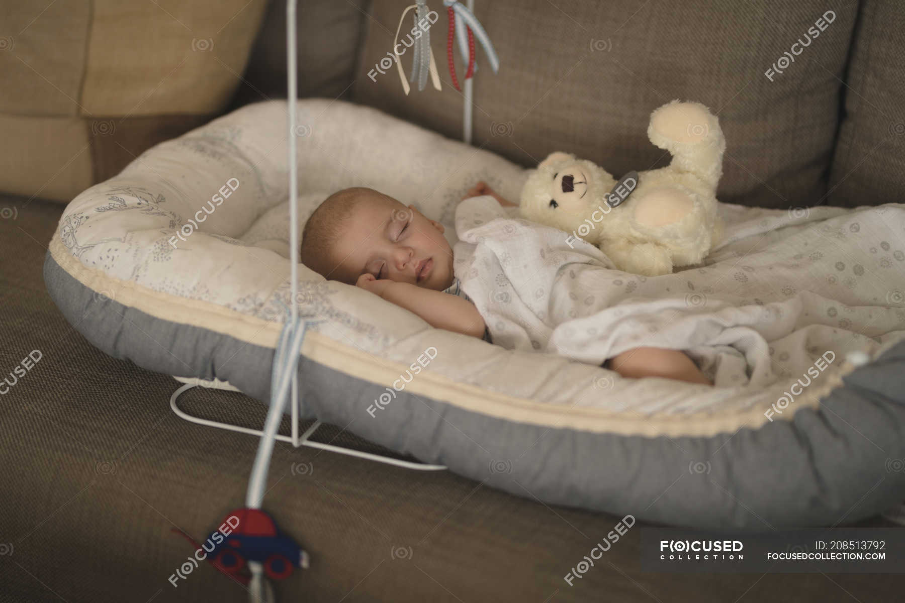 Cute little baby sleeping in the crib on sofa at home — authentic