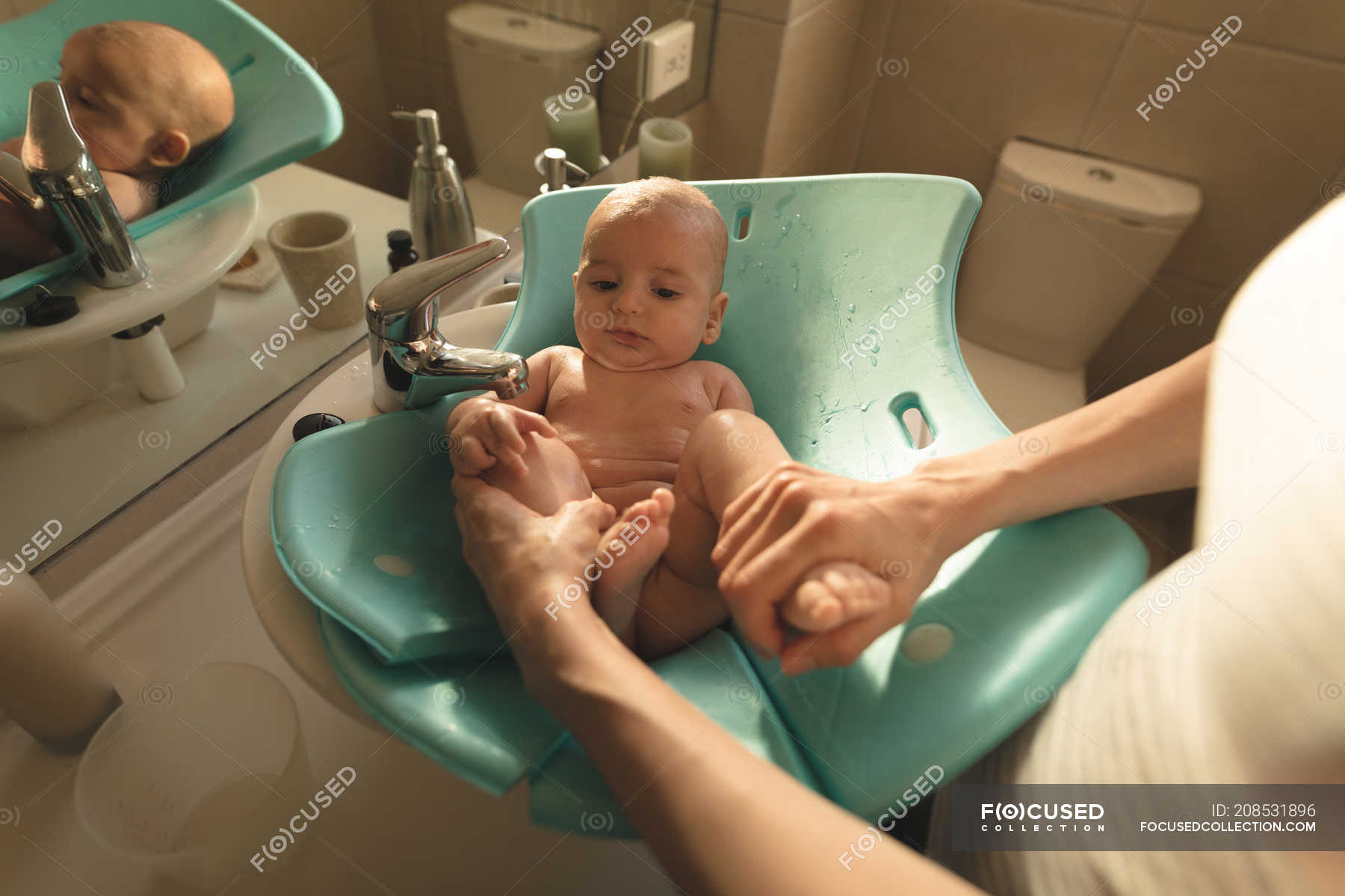 Mother Washing A Baby In Bath Seat, How To Clean Baby Bathtub