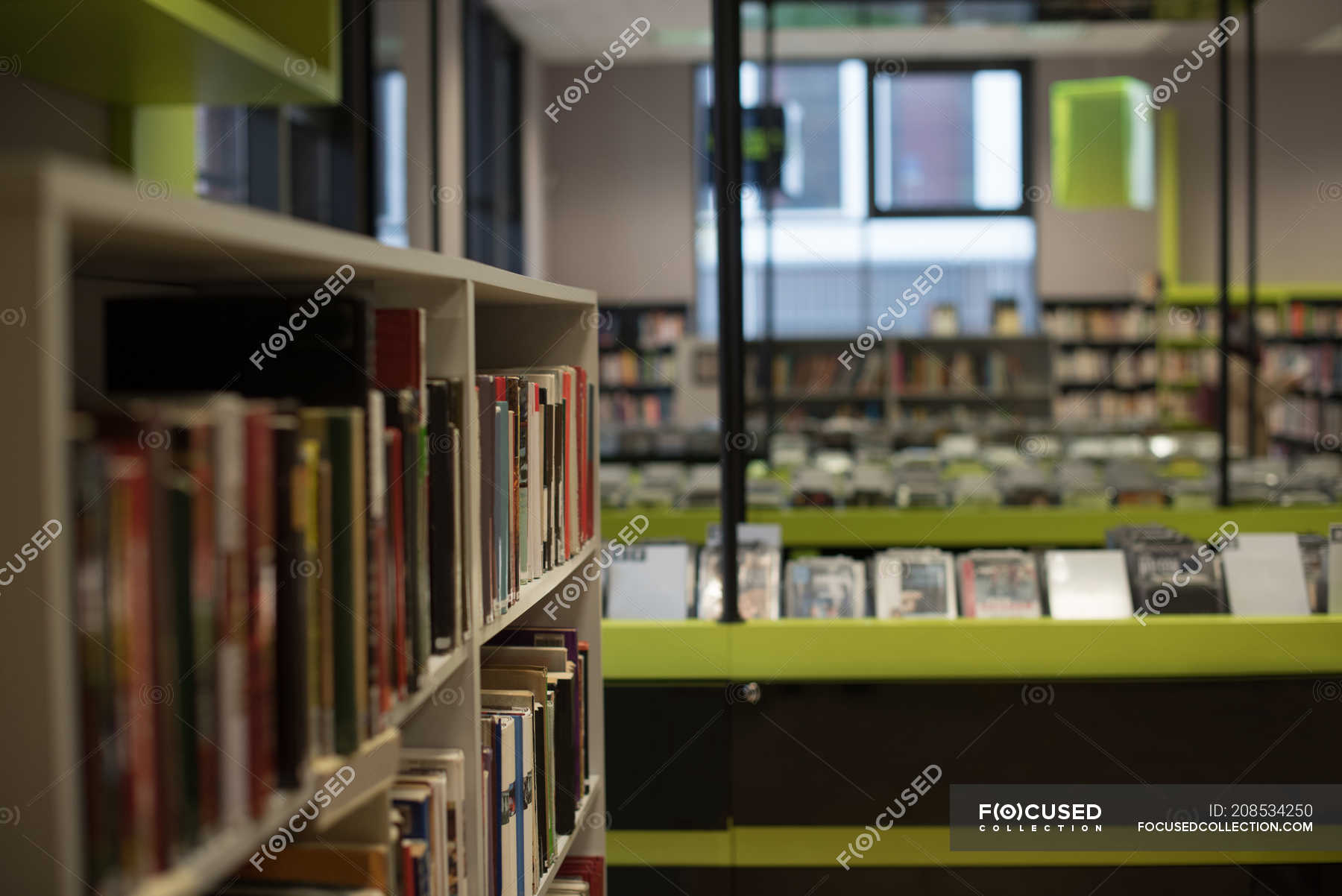 Books arranged in book shelf in library — information, background