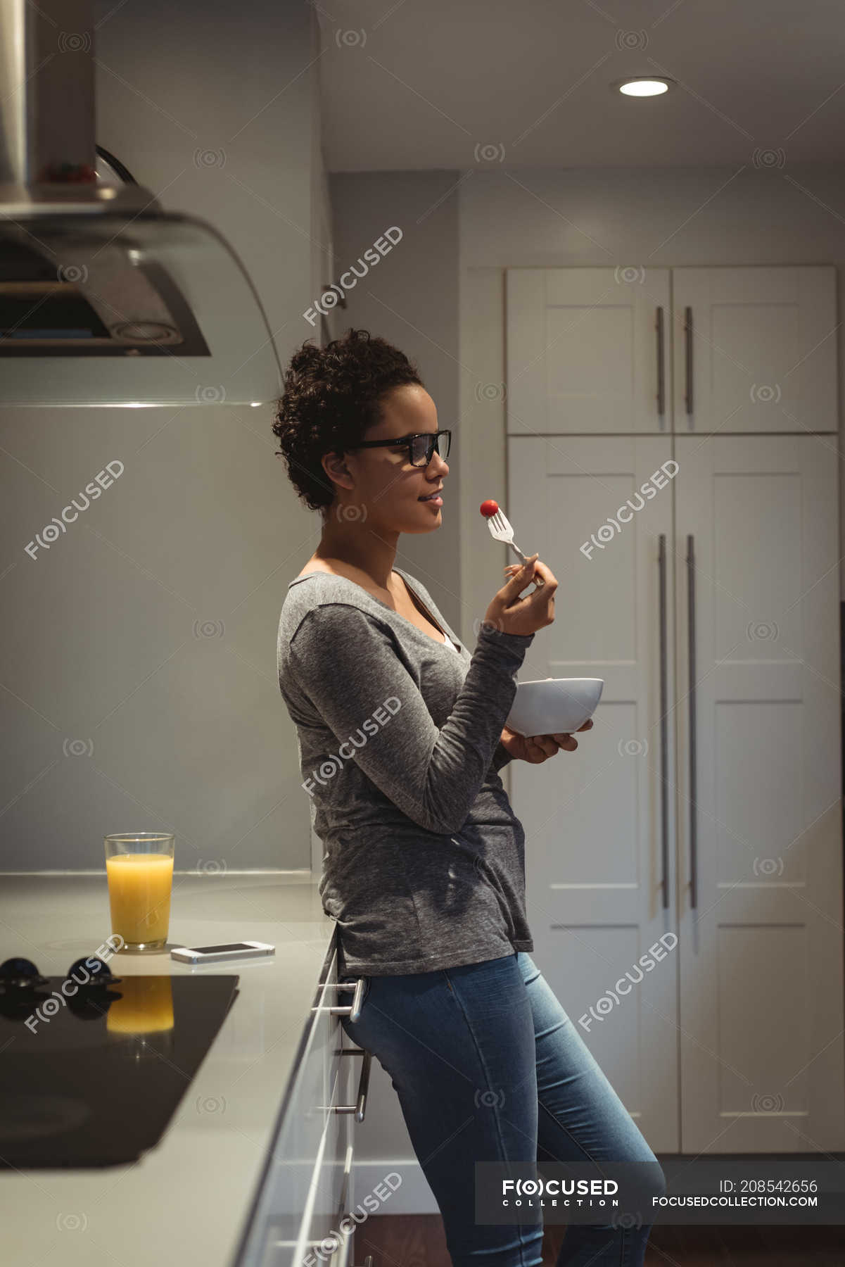 Young Pregnant Woman Leaning On Kitchen Counter Having Food — Abdomen