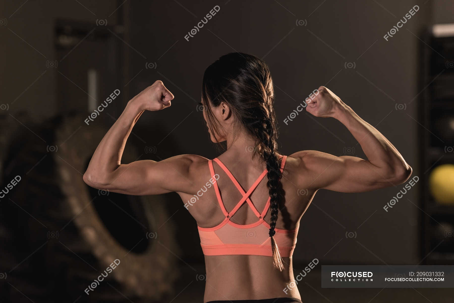 Vista Trasera De La Mujer En Forma Flexionando Sus Músculos En El Gimnasio — Centrado 5740