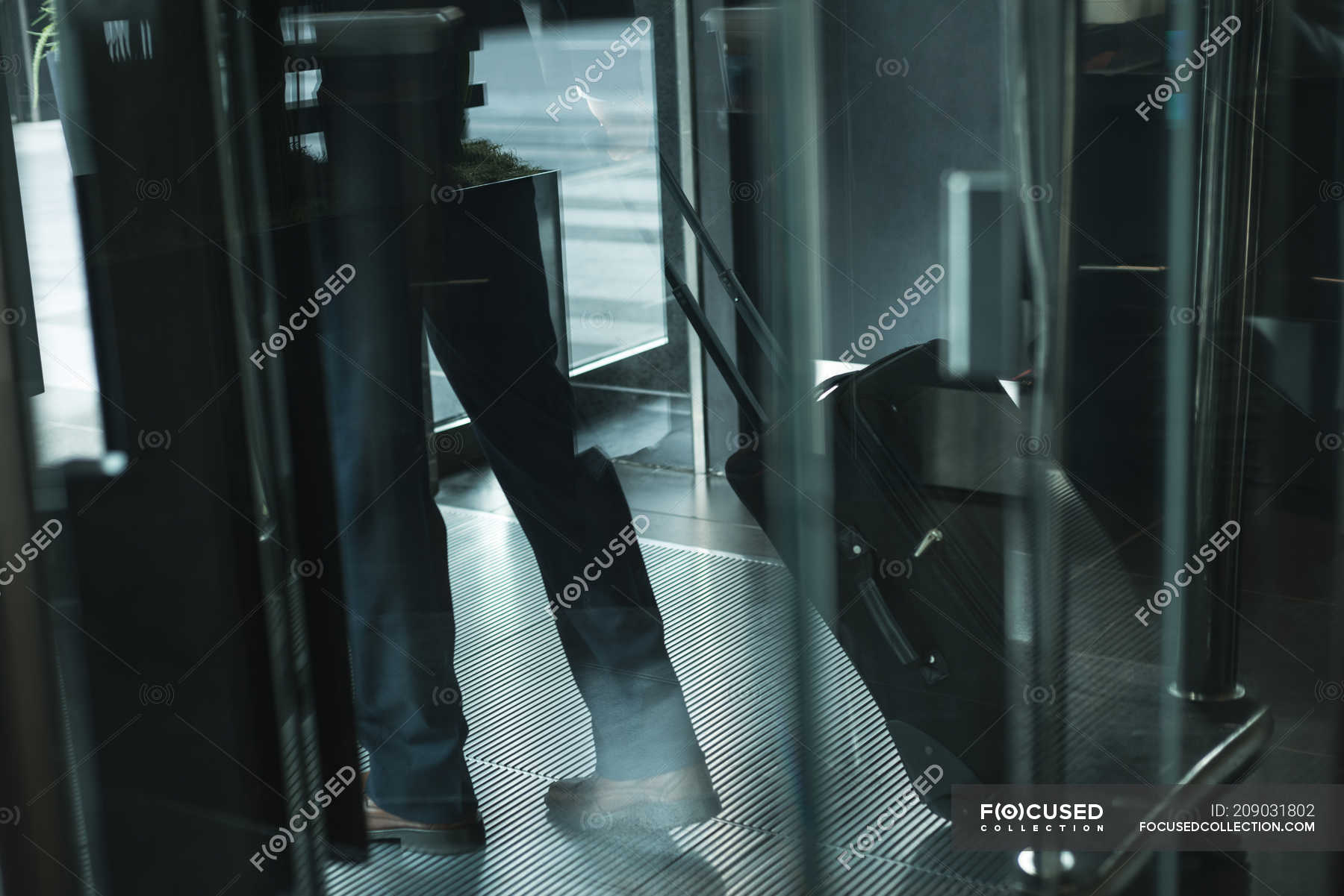 Cropped image of businessman leaving from hotel — low section, Business ...