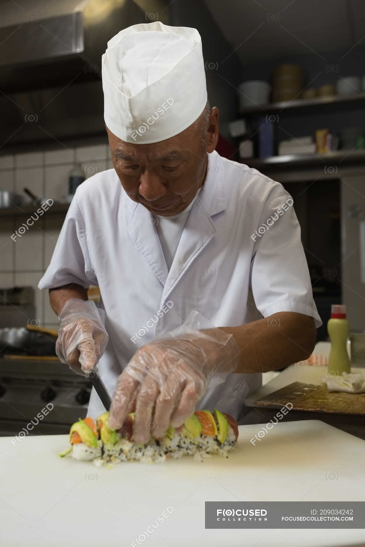 Expensive images and pictures of Senior chef preparing sushi in kitchen at ...