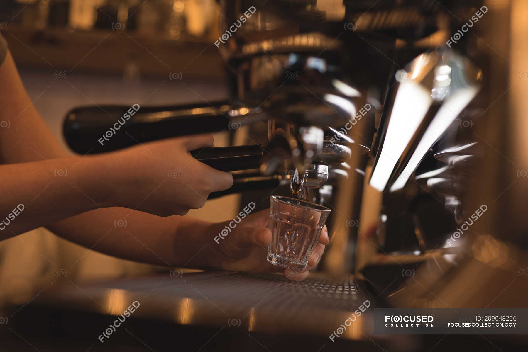 Barista preparing coffee at counter in cafe — leisure, staff Stock