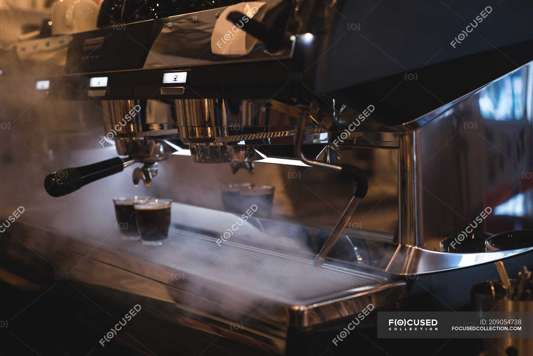 Coffee glasses kept on steamed espresso machine in cafe — dispenser