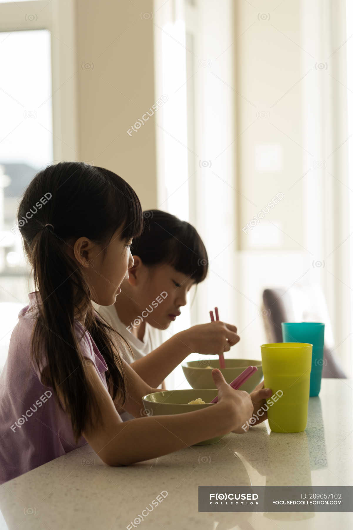 Adorable siblings having breakfast at home — relationship, glass ...