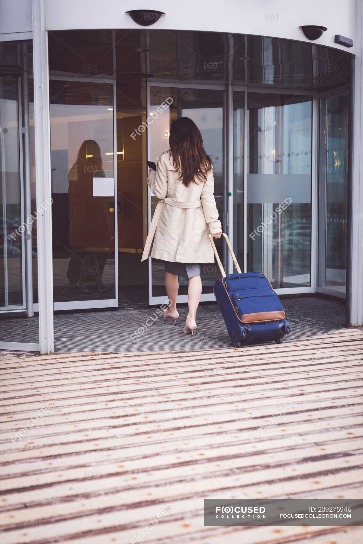 Rear view of businesswoman arriving in hotel — Business Travel, walking Stock Photo 209275946