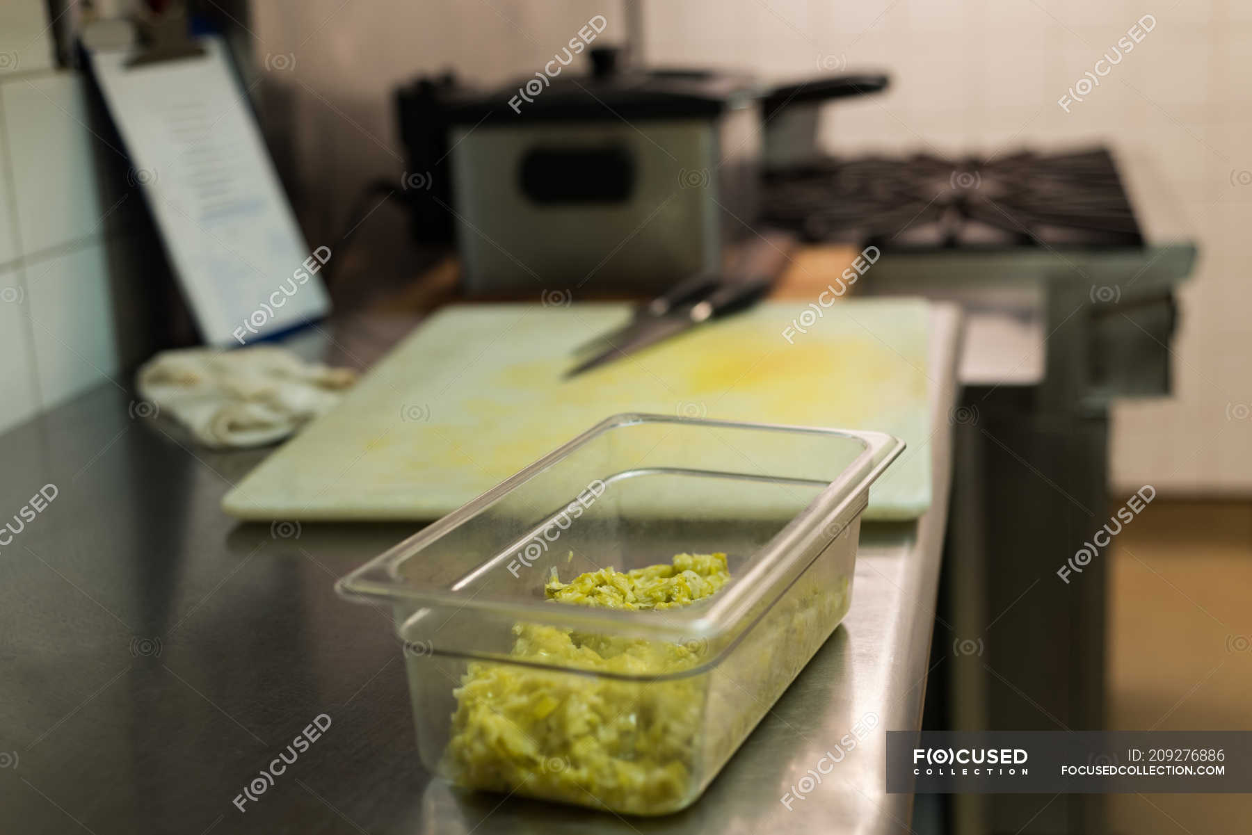 Container of chopped vegetable on the counter at commercial kitchen