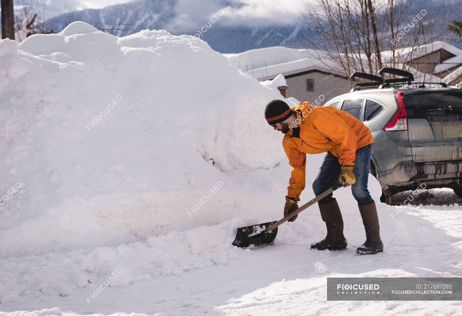 man-cleaning-snow-with-snow-shovel-during-winter-20s-outdoors