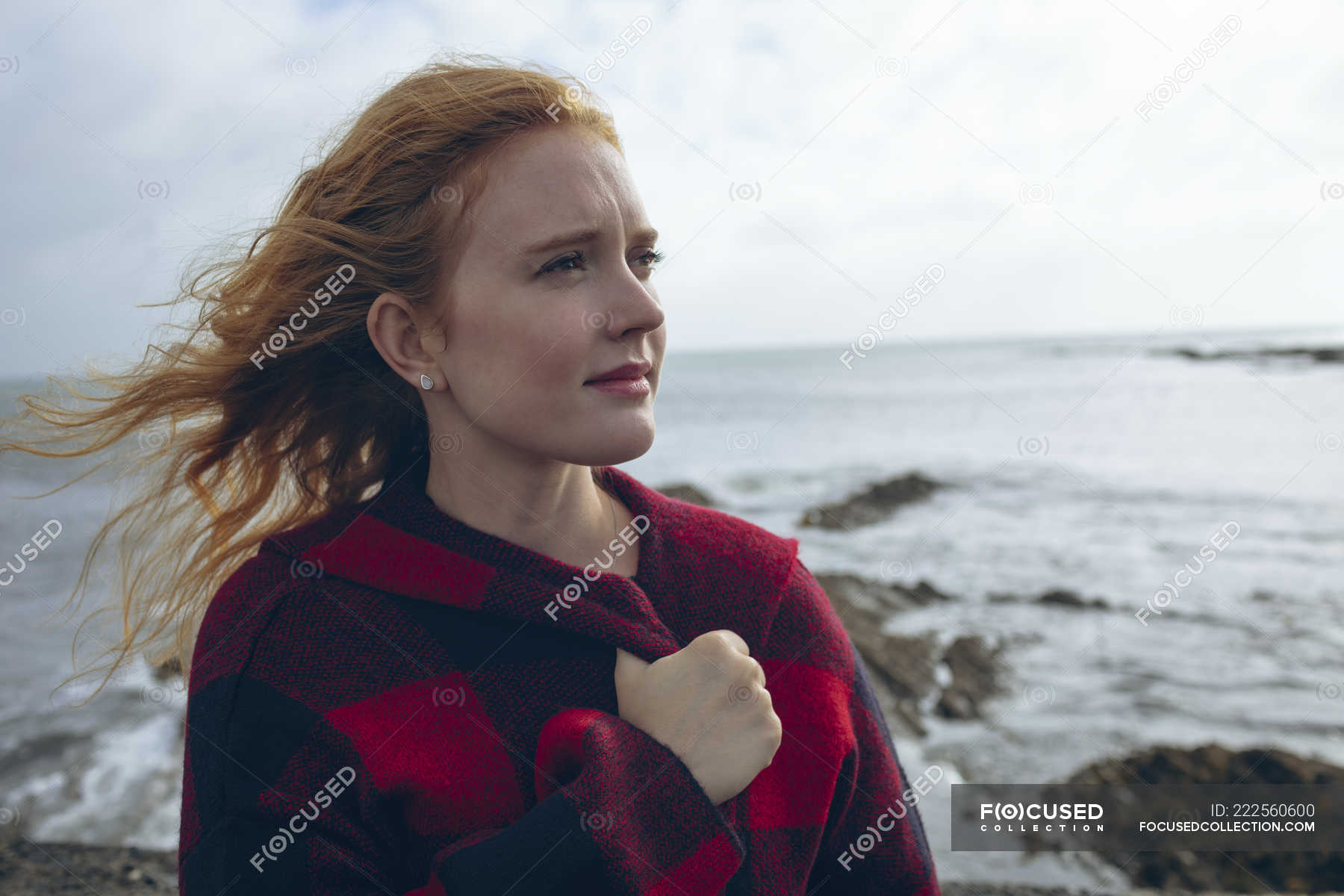 Thoughtful Redhead Woman Standing In Windy Beach County Cork Water Stock Photo