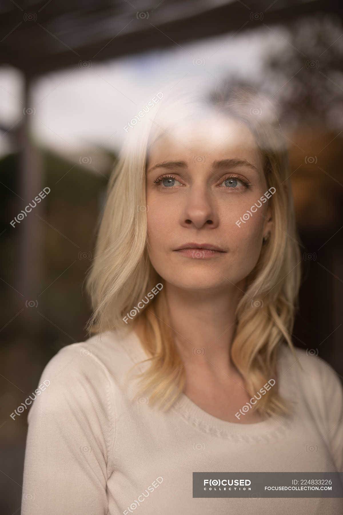 Thoughtful woman looking through window at home — caucasian ethnicity ...