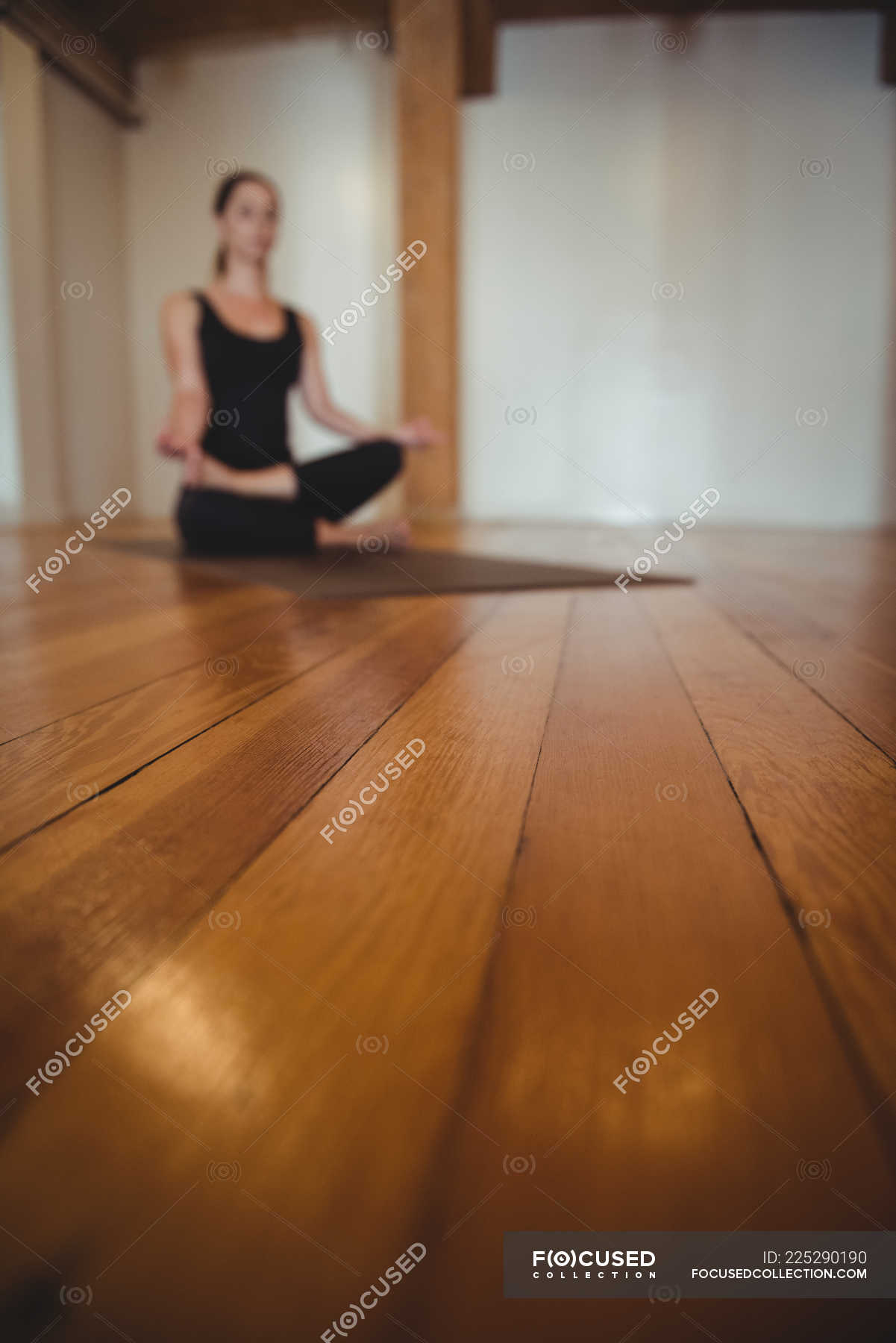 Close Up Of Wooden Flooring In Fitness Studio With Practicing Woman In Background Gymnasium Healthy Lifestyle Stock Photo