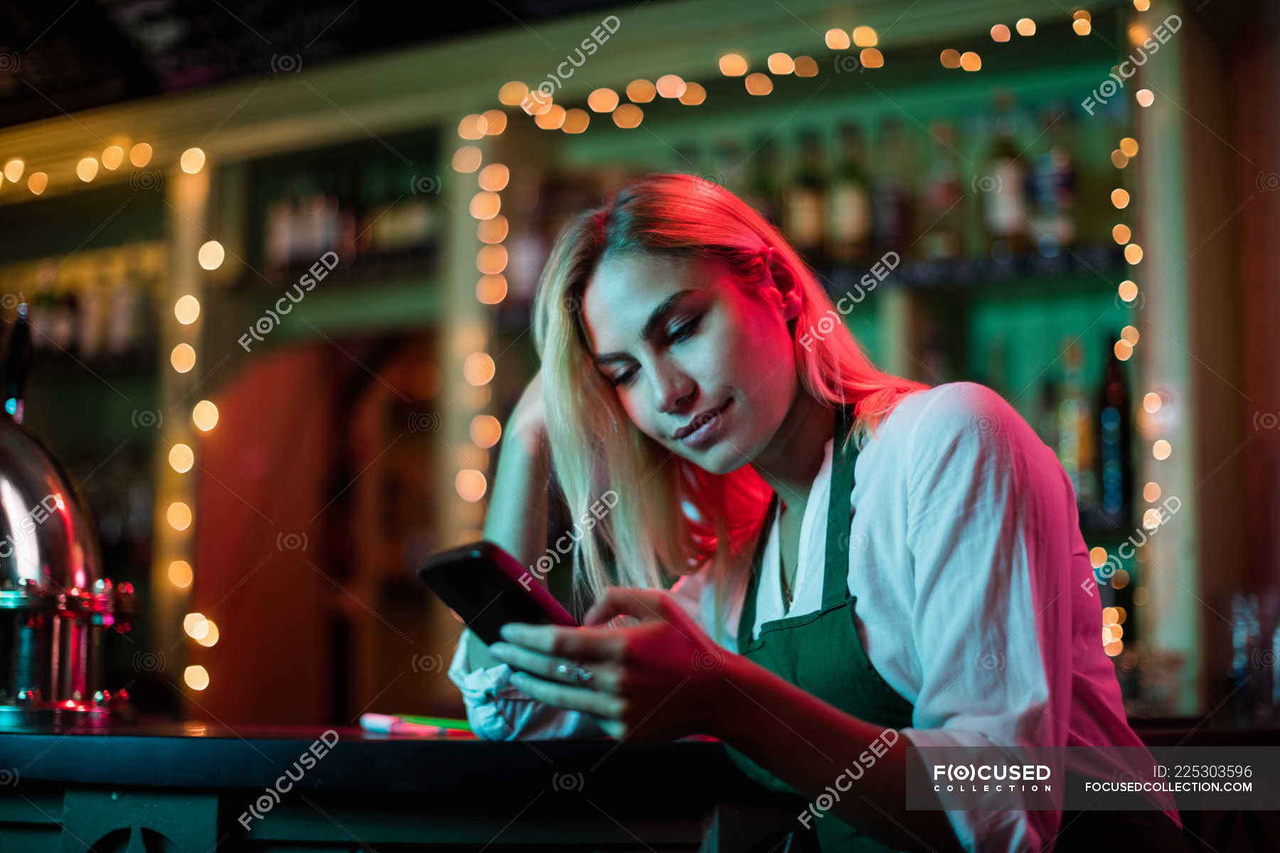 Waitress Using Her Mobile Phone At The Bar Counter — Hospitality