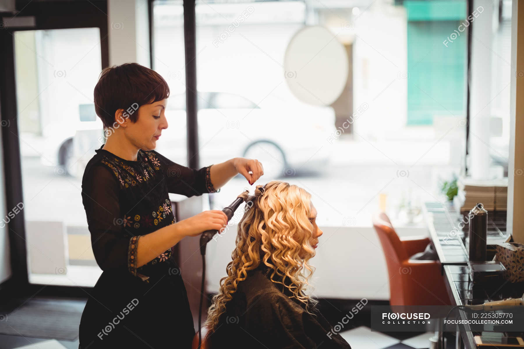 Female hairdresser styling clients hair in saloon — Grooming, Expertise ...