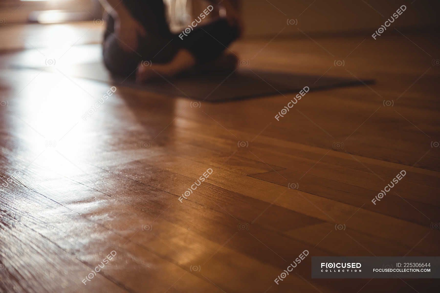 Close Up Of Wooden Flooring In Fitness Studio And Practicing Person In Background Activity Yoga Stock Photo