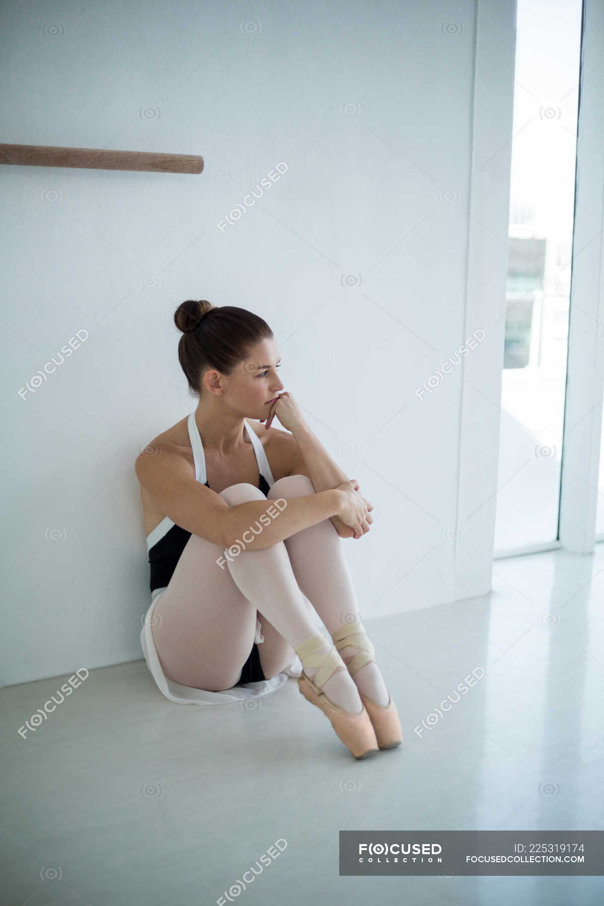 Thoughtful ballerina sitting on floor in ballet studio agility, talent - Stock Photo | #225319174