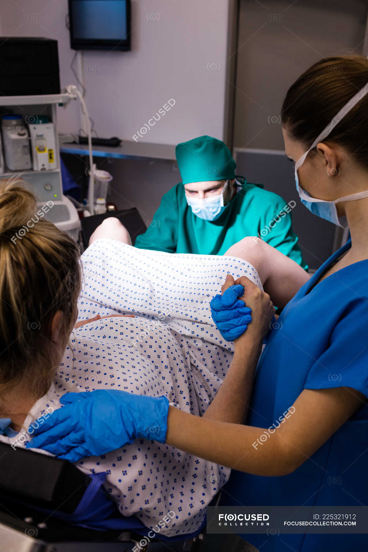 Medical Team Examining Pregnant Woman During Delivery In Operating Room