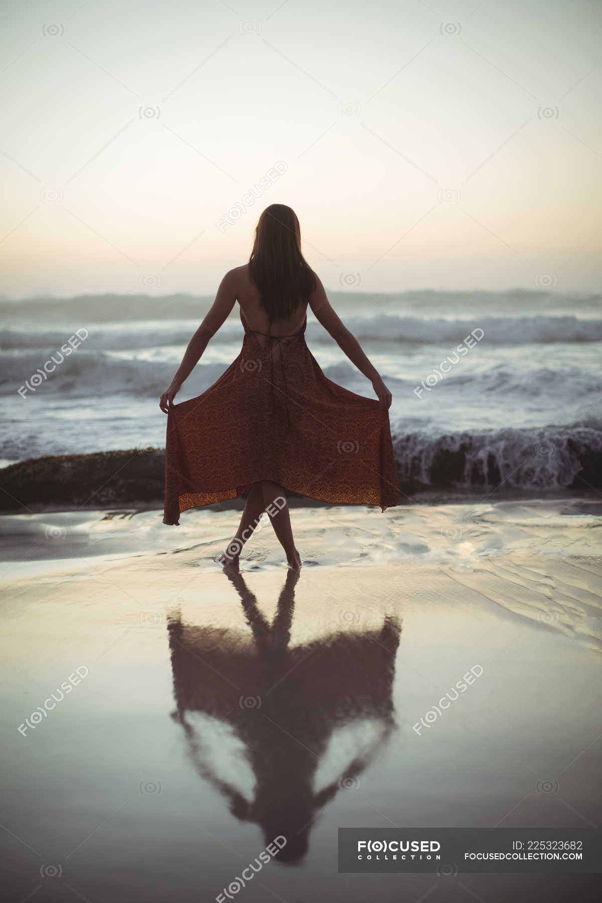 Rear View Of Woman Posing On Beach At Dusk Modern Model Stock Photo